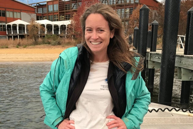 A woman standing on a boat in front of a dock on the Chesapeake Bay.