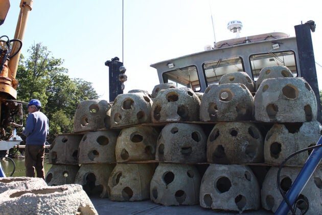 Dozens of concrete reef balls are stacked three high on the deck of the Patricia Campbell.