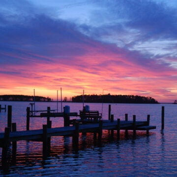 A colorful sky marks sunset overlooking a pier on the Bay.