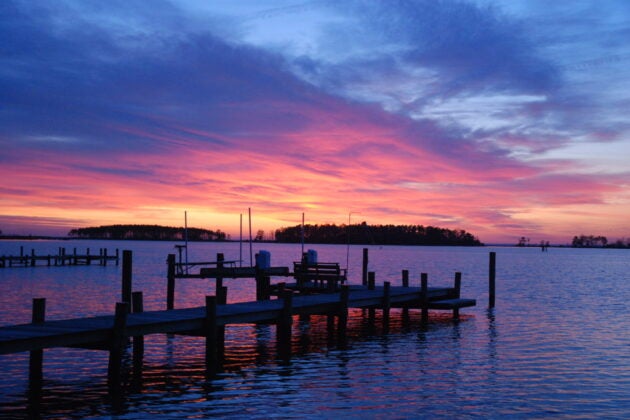 A colorful sky marks sunset overlooking a pier on the Bay.