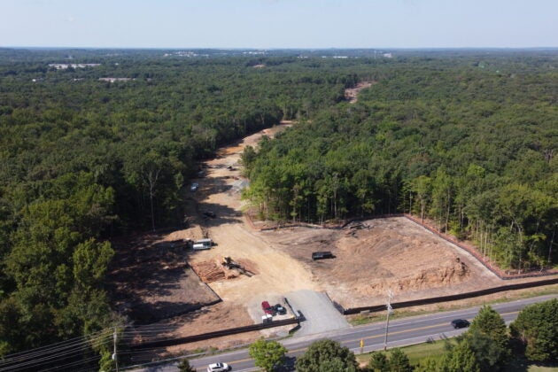 Bulldozed land scars a green forest.