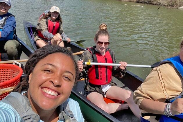 Students from the Bay Advocacy Institute paddle canoes on a sunny day, enjoying hands-on environmental education on a calm river.