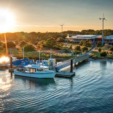 Twilight aerial view of the Brock Center and its dock with the mobile oyster restoration center and education boat the Jenny S.