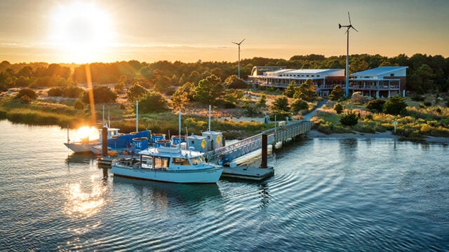 Twilight aerial view of the Brock Center and its dock with the mobile oyster restoration center and education boat the Jenny S.