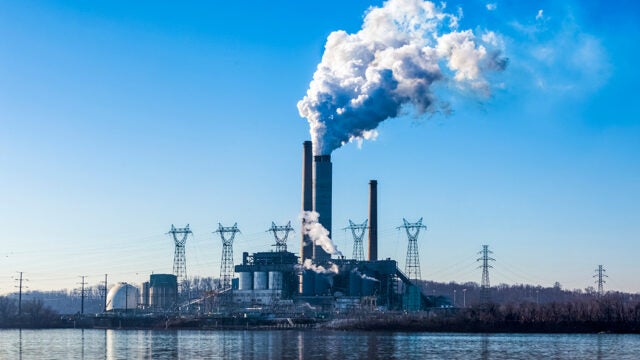 A power plant, with thick clouds emitting from a set of towers.