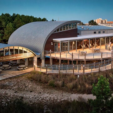 Lights illuminate the outside of the Brock Environmental Center at dusk.