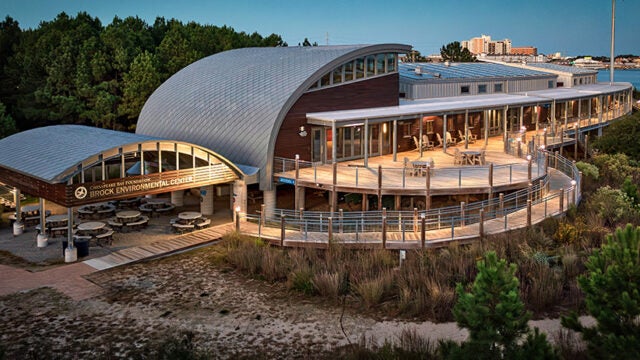 Lights illuminate the outside of the Brock Environmental Center at dusk.