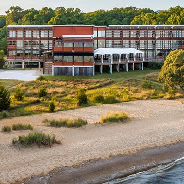 Rolling surf, a sandy beach, and grassy area off the back of the Philip Merrill Environmental Center.