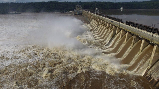 The Conowingo Dam with flood gates open and water rushing through.
