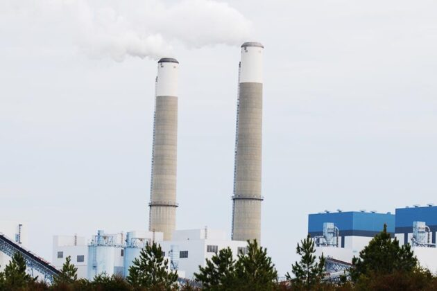The Clover Power Station in Virginia with two tall smokestacks releasing steam above the industrial facility