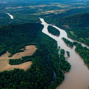 A river runs through forests and farmland.
