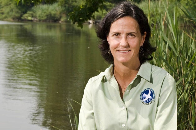 Dr. Beth McGee sits beside a pond.