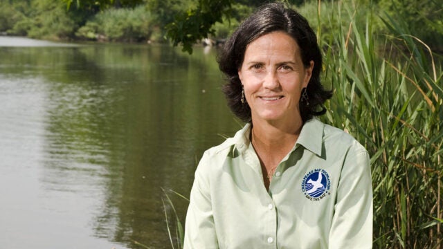 Dr. Beth McGee sits beside a pond.