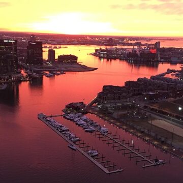 Aerial view of the Baltimore Inner Harbor at sunrise in dramatic orange light