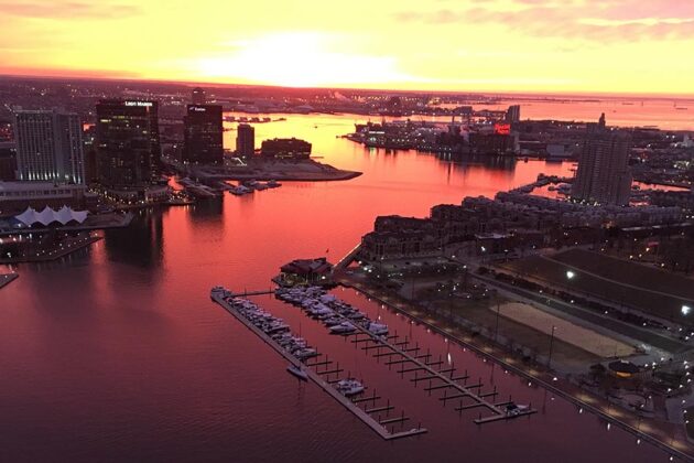 Aerial view of the Baltimore Inner Harbor at sunrise in dramatic orange light