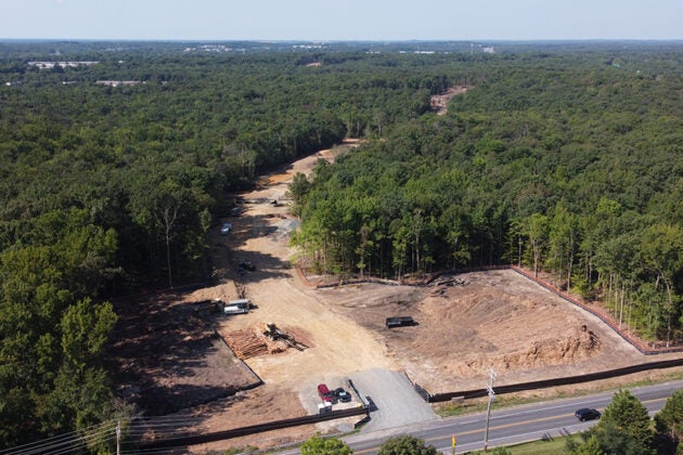 Aerial view of cleared construction site in a forested area.