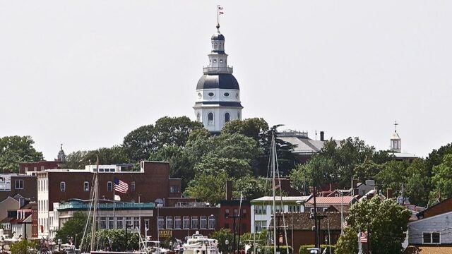 The Maryland State House dome rising above the historic buildings and sailboat masts of downtown Annapolis.