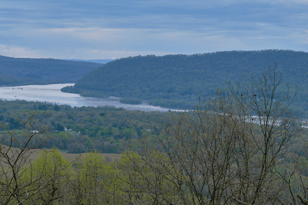 The view from Peters Mountain showing a river winding through a forested valley with rolling mountains in the distance.
