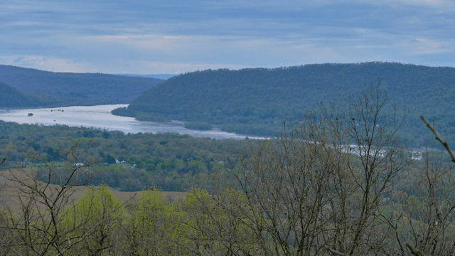 The view from Peters Mountain showing a river winding through a forested valley with rolling mountains in the distance.