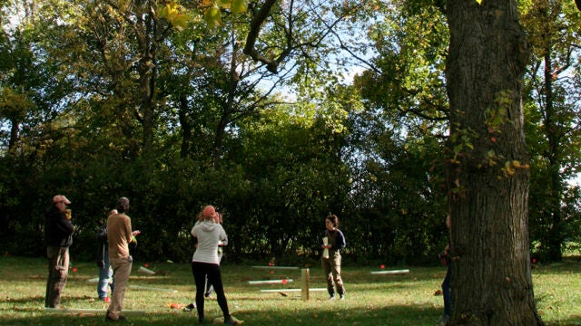 A group of people prepare to plant trees.