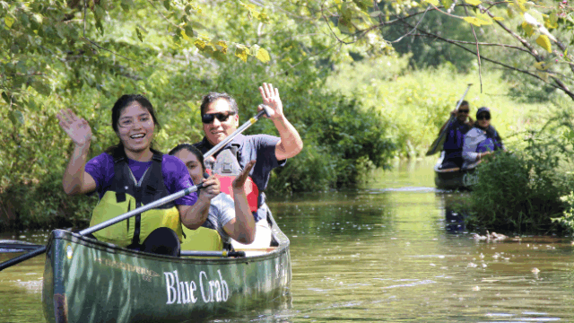 Students paddle a canoe.