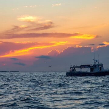 Fishing boat on the Chesapeake Bay at sunset with dramatic sky.