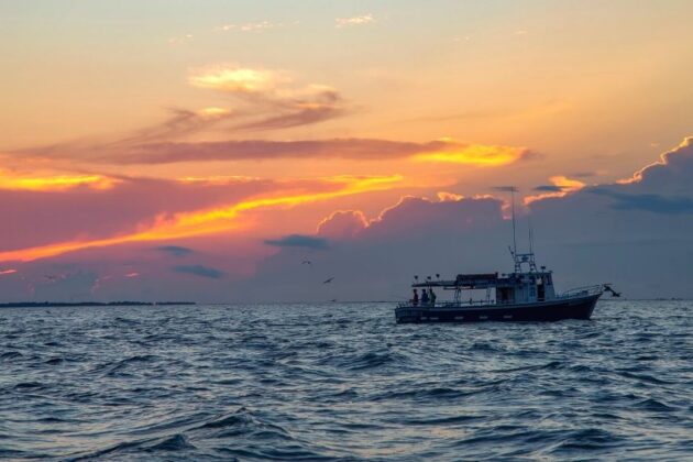 Fishing boat on the Chesapeake Bay at sunset with dramatic sky.